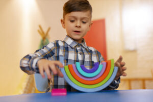 Imagem de uma criança brincando com peças coloridas.